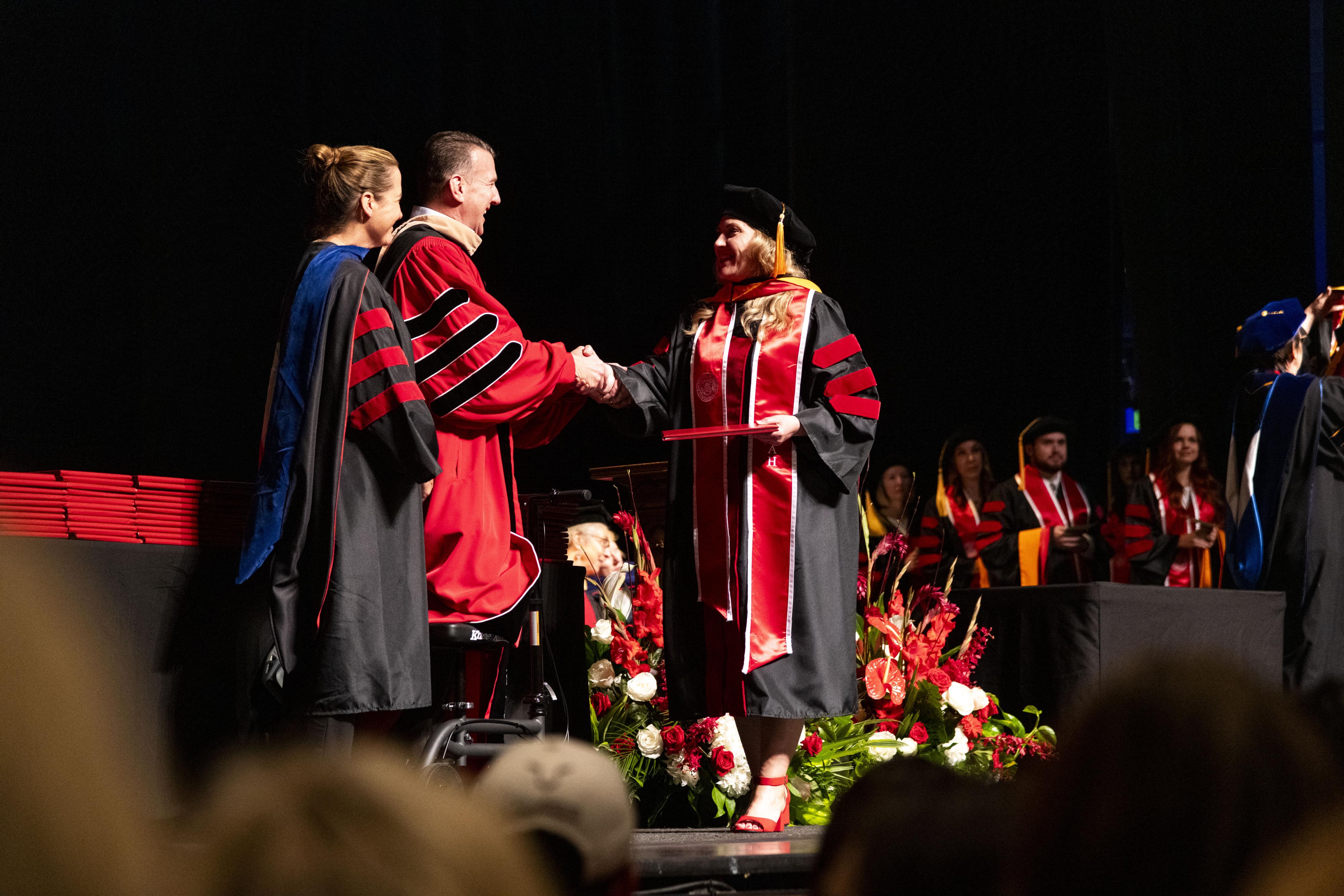 A graduate receives a diploma on the stage