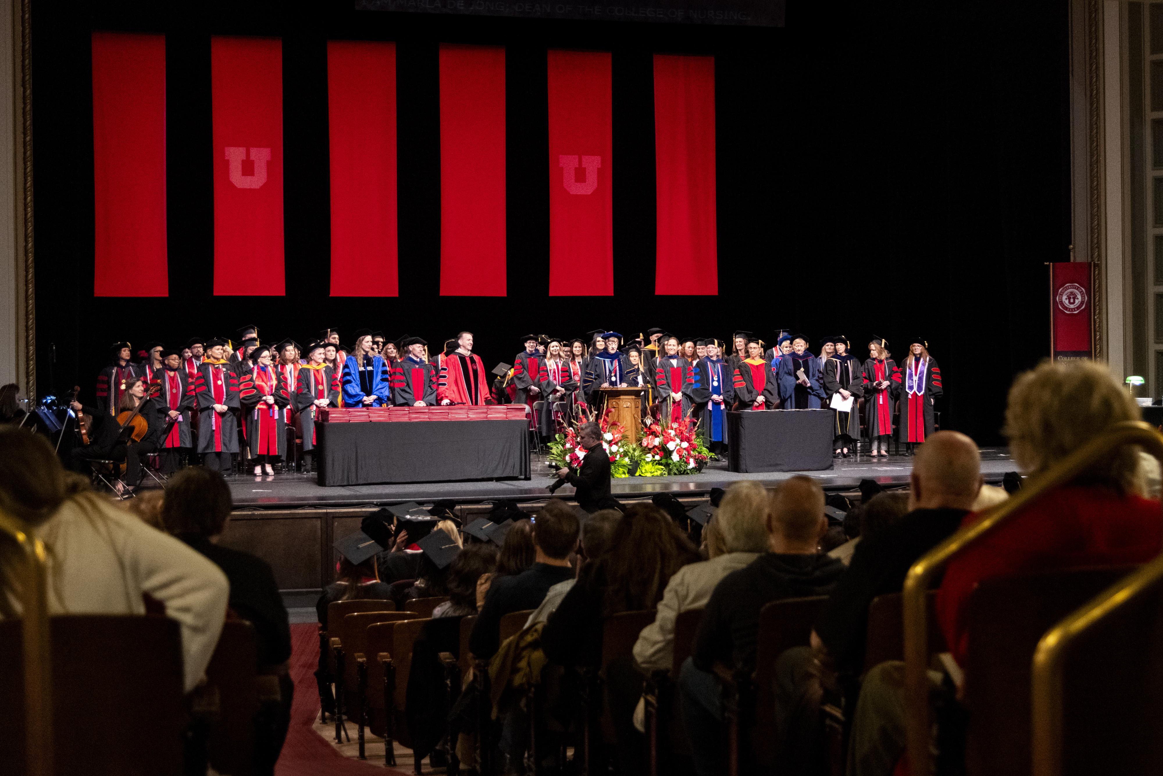 Faculty of the College of Nursing stand on the podium