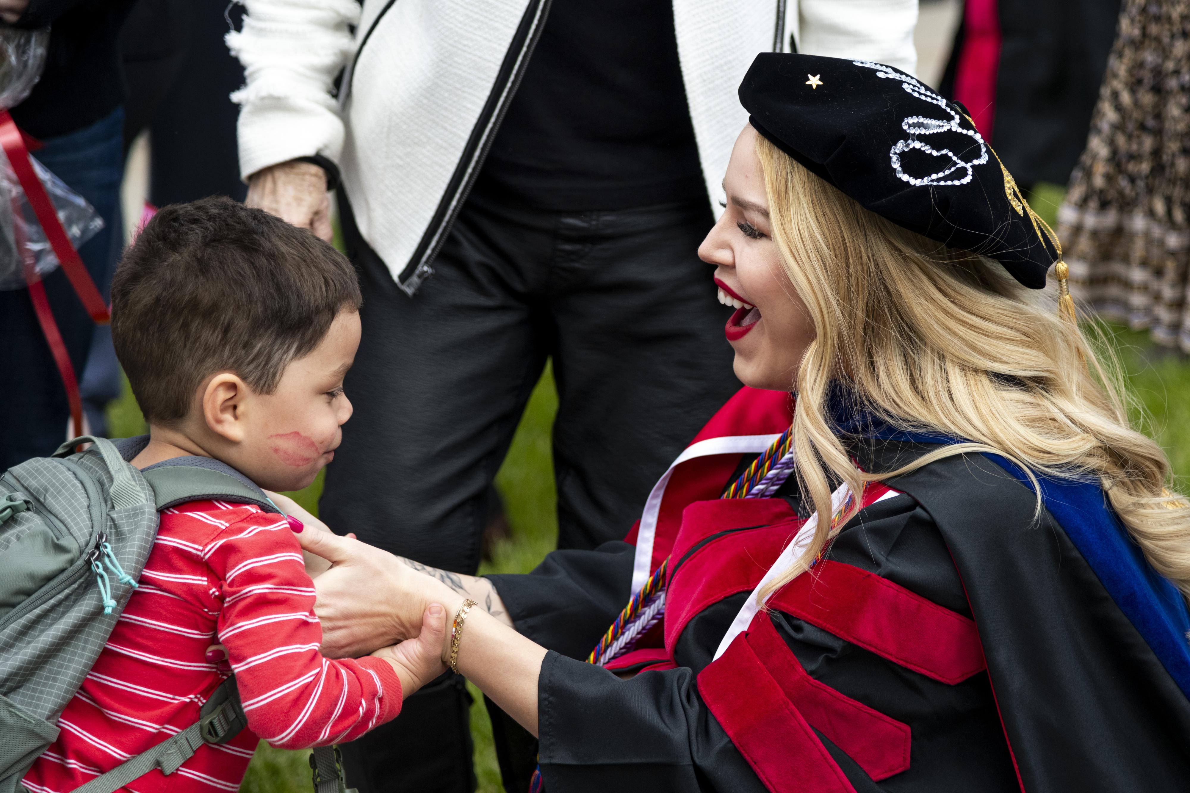 A graduate embraces a child after the ceremony