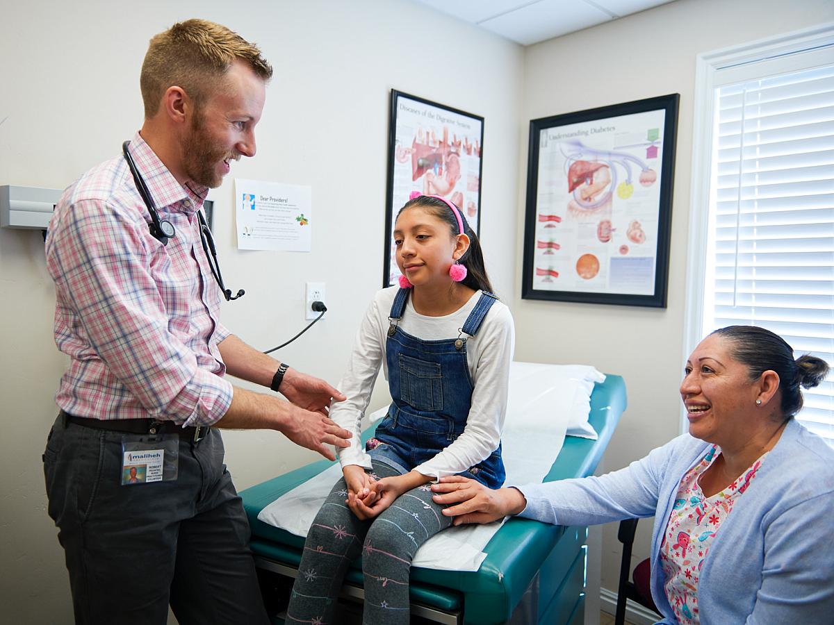 nurse practitioner helping a pediatric patient