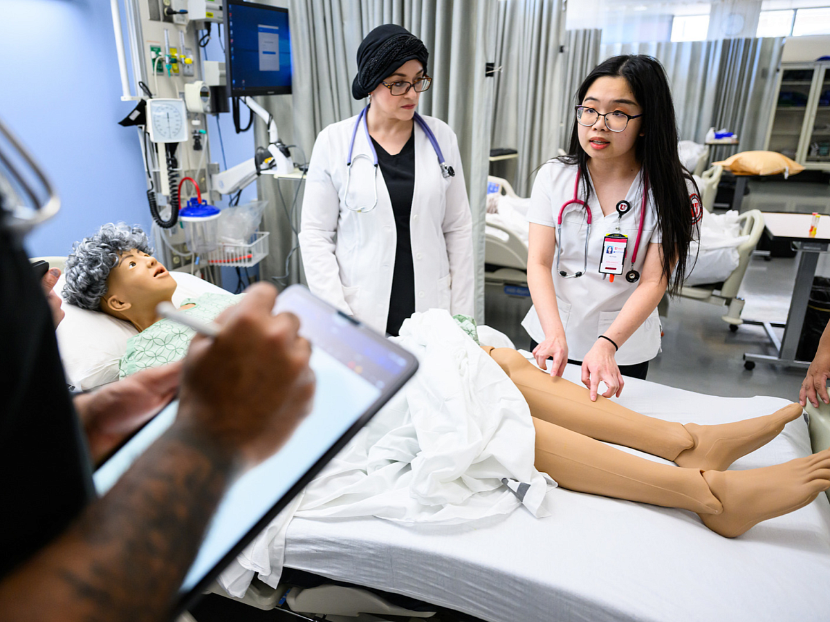 students with dean in simulation lab